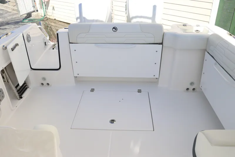 Slide: The Image of 2024 Edgewater 262CX boat interior, spacious deck with storage compartments. - 17