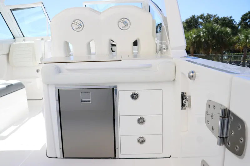 Slide: The Image of 2024 Edgewater 262CX boat interior with storage drawers and stainless steel fridge. - 24