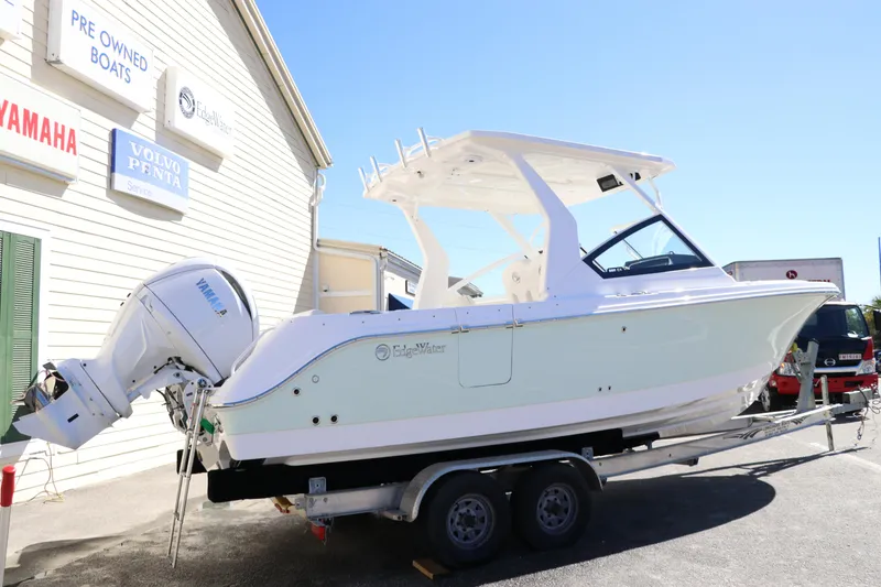 Slide: The Image of 2024 Edgewater 262CX boat on a trailer outside a dealership. - 3