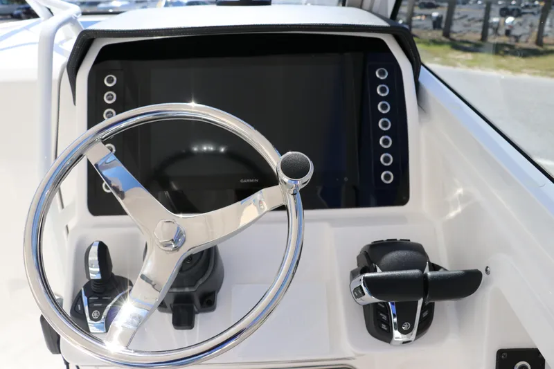 Slide: The Image of 2024 Edgewater 262CX boat helm with steering wheel and control panel. - 36