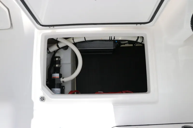Slide: The Image of 2024 Edgewater 262CX storage compartment with visible hoses and equipment. - 41