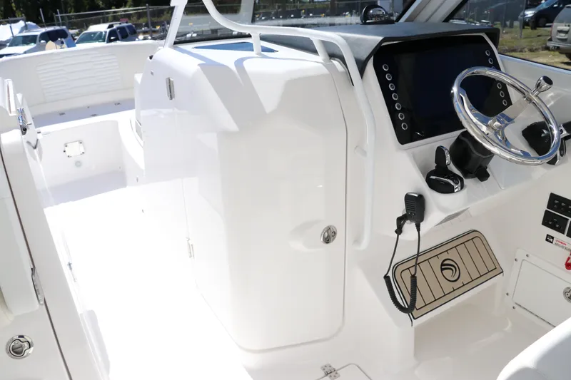 Slide: The Image of 2024 Edgewater 262CX boat cockpit with steering wheel and control panel. - 47