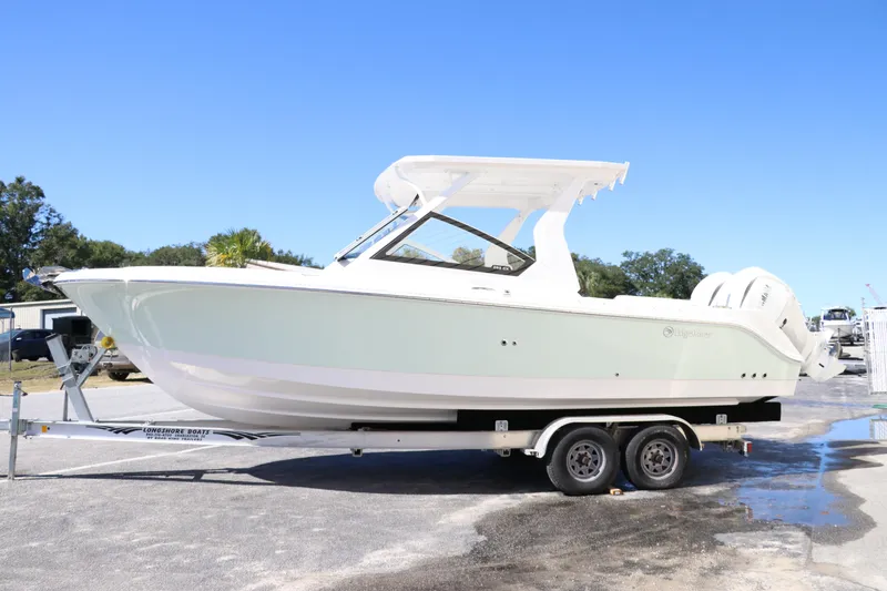 Slide: The Image of 2024 Edgewater 262CX boat on a trailer, side view, outdoors. - 6