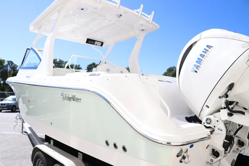 Slide: The Image of 2024 Edgewater 262CX boat with Yamaha engine, docked on a trailer, under clear blue sky. - 7