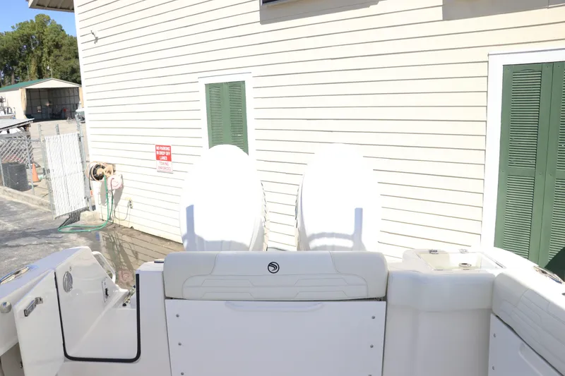 Slide: The Image of 2024 Edgewater 262CX boat with dual outboard engines docked near a building. - 9