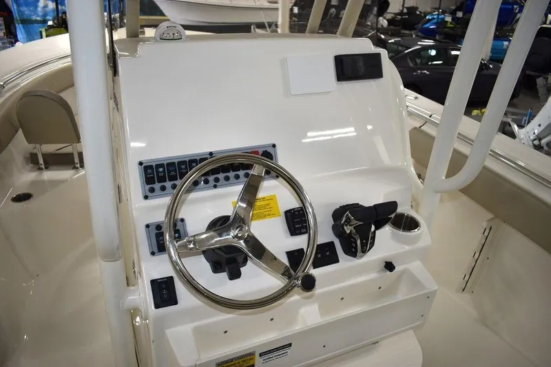 Slide: The Image of 2024 Key West 244 CC boat console with steering wheel and controls. - 24