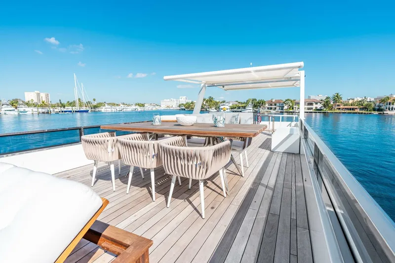 Slide: The Image of Luxury deck of Reina L44 DR yacht, 2024 model, with dining area and waterfront view. - 10