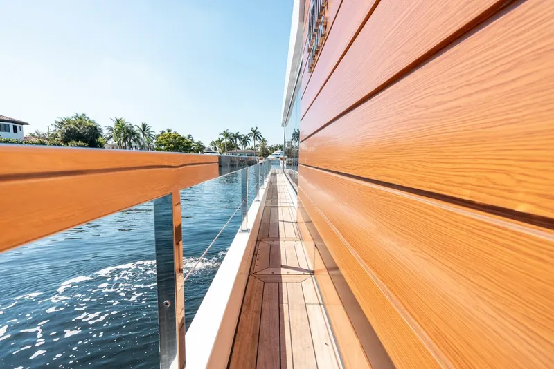 Slide: The Image of Side deck of 2024 Reina L44 DR yacht with wooden paneling and water view. - 13