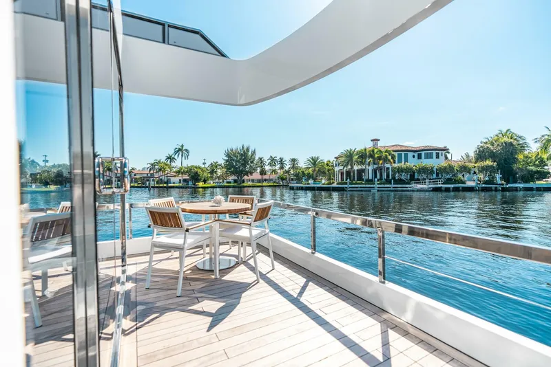 Slide: The Image of Luxury yacht deck with dining area overlooking waterfront homes, Reina L44 DR 2024 model. - 14