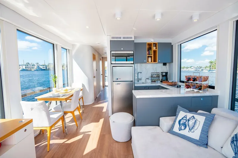 Slide: The Image of Modern 2024 Reina L44 DR houseboat interior with kitchen, dining area, and waterfront views. - 18