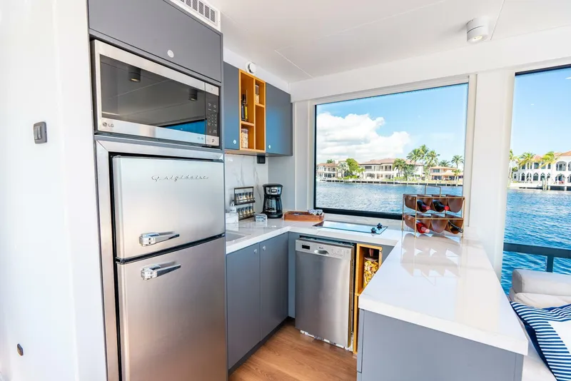 Slide: The Image of Modern kitchen in Reina L44 DR 2024 yacht with stainless steel appliances and waterfront view. - 19