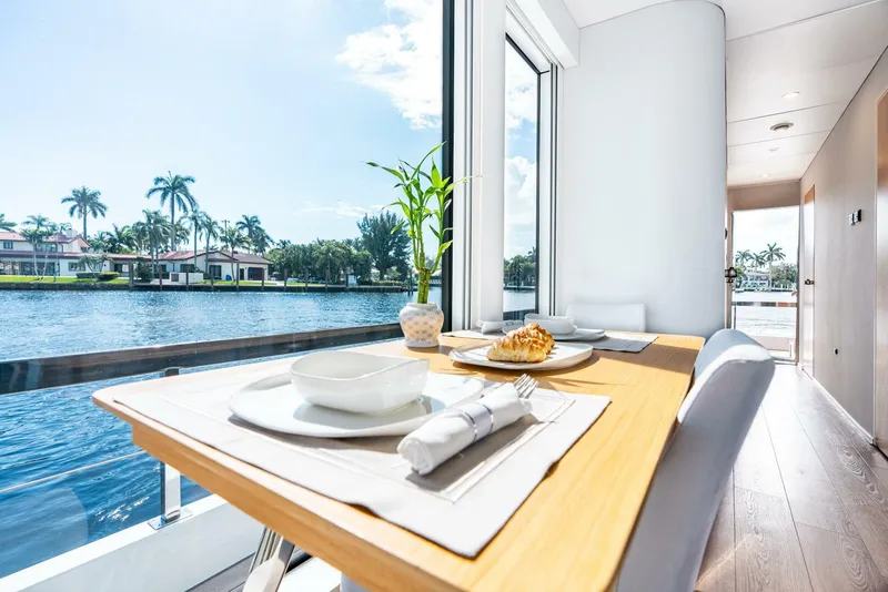 Slide: The Image of Modern dining area on Reina L44 DR yacht, 2024 model, with waterfront view. - 20