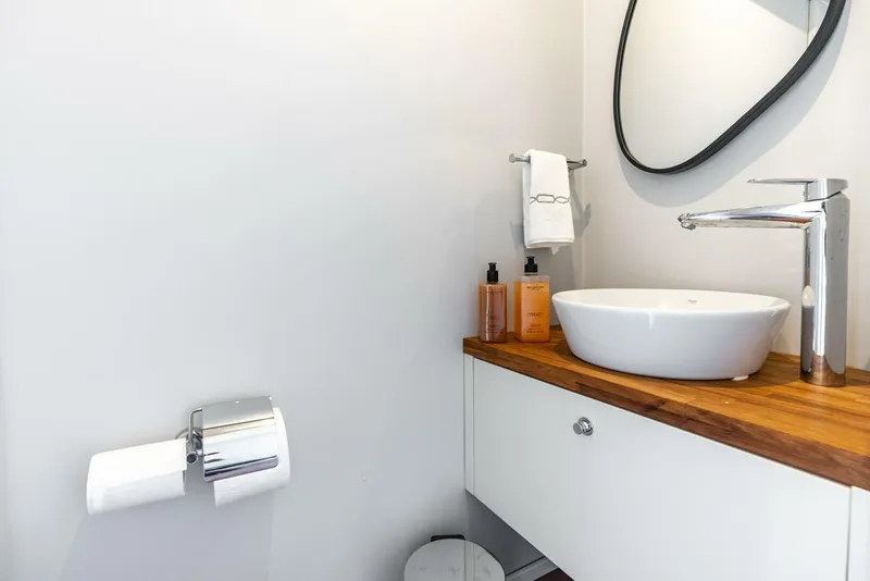Slide: The Image of Modern bathroom with vessel sink, wooden countertop, and Reina L44 DR faucet, 2024 model. - 26