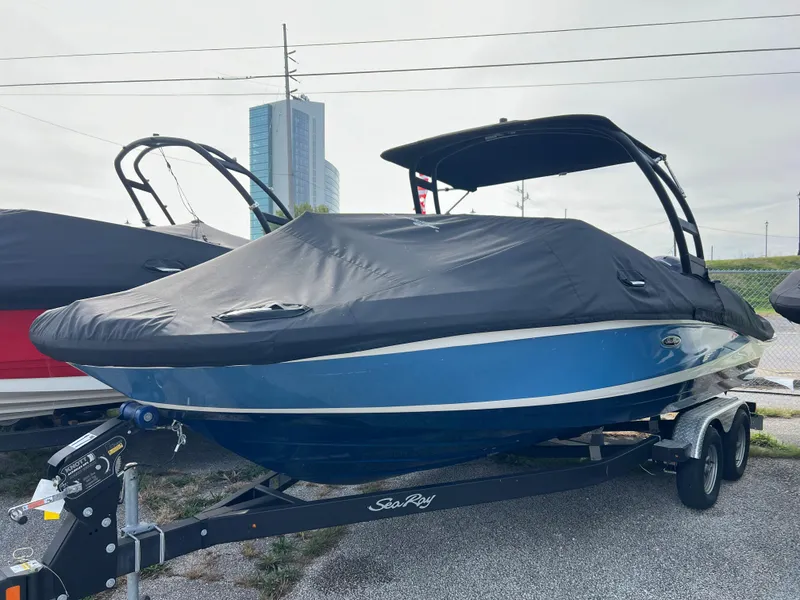 Slide: The Image of 2021 Sea Ray SPO 210 boat with cover on trailer, parked outdoors. - 11