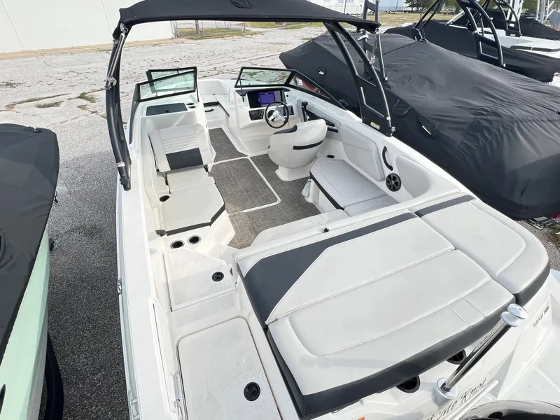 Slide: The Image of 2021 Sea Ray SPO 210 boat interior with seating and steering wheel. - 2
