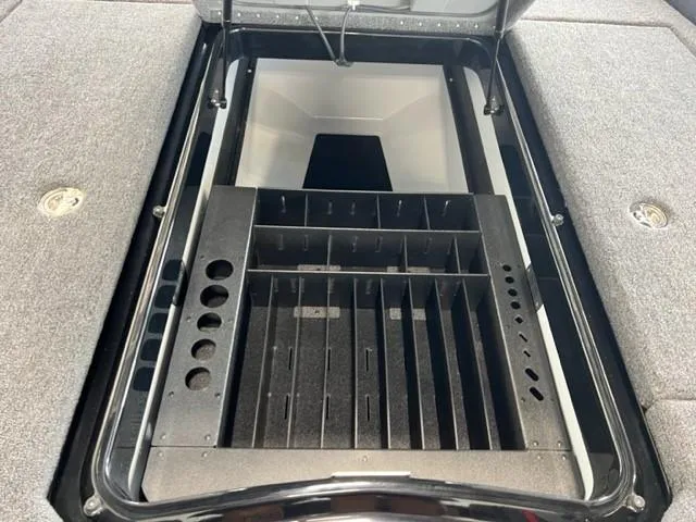 Slide: The Image of 2024 iKon LX21 boat storage compartment with organized tackle trays and rod holders. - 15