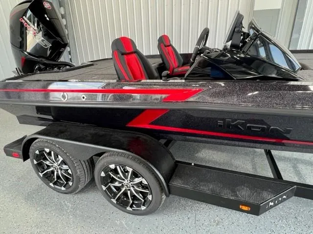 Slide: The Image of 2024 iKon LX21 boat with red and black design on a dual-axle trailer. - 2