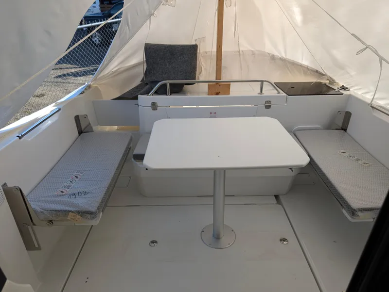 Slide: The Image of 2023 Jeanneau NC 695 Sport S2 interior with seating and table setup. - 11
