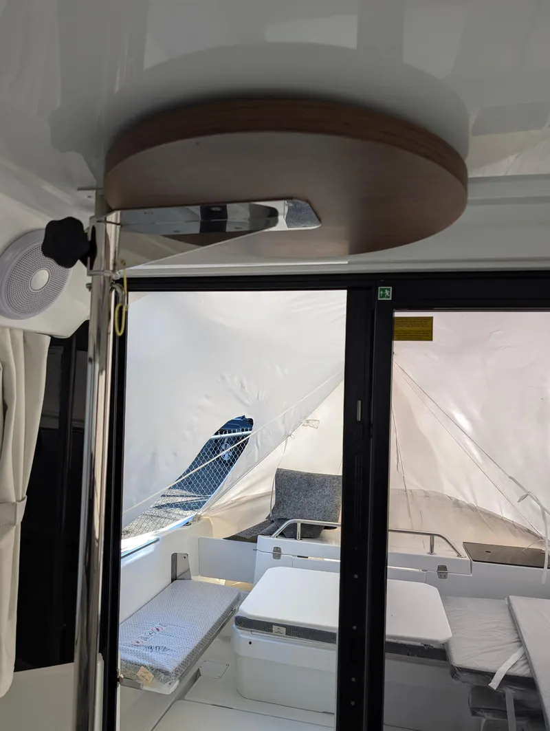 Slide: The Image of Interior view of 2023 Jeanneau NC 695 Sport S2 boat, featuring modern seating and sliding doors. - 5