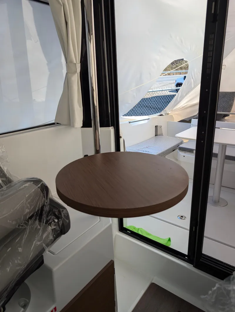 Slide: The Image of Interior of 2023 Jeanneau NC 695 Sport S2 with round wooden table and sliding door. - 6