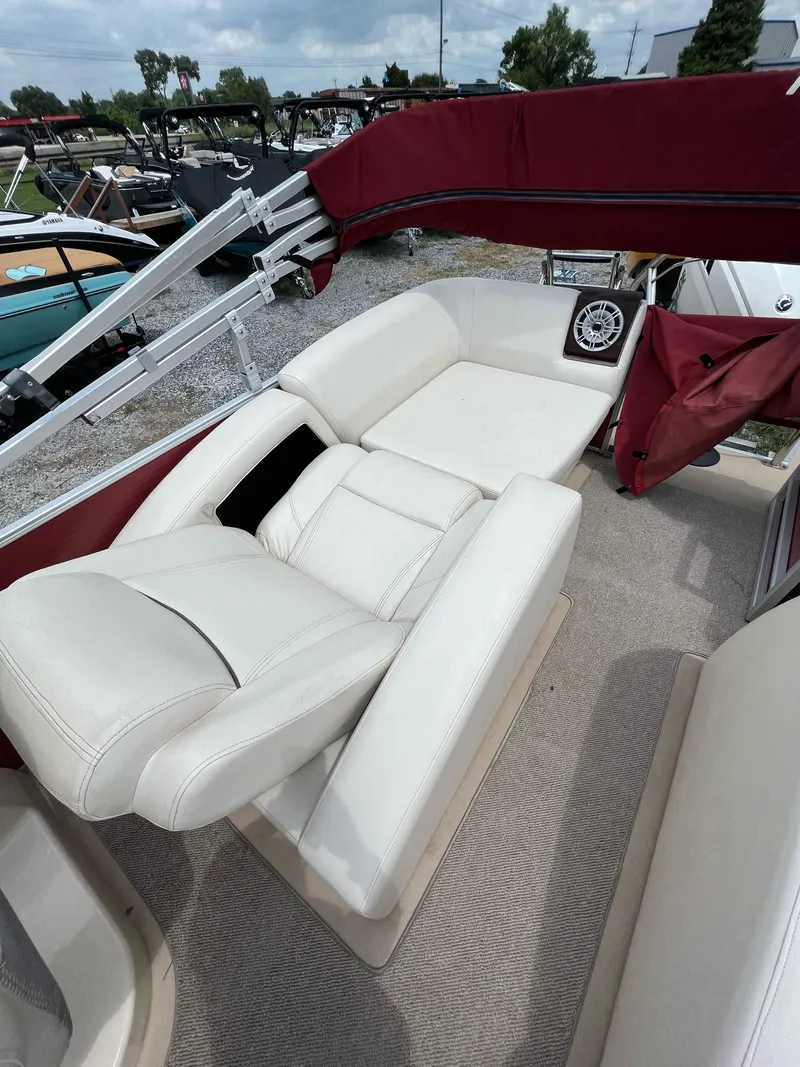 Slide: The Image of 2015 AquaPatio 240 SLR boat with white leather seating and maroon canopy. - 3
