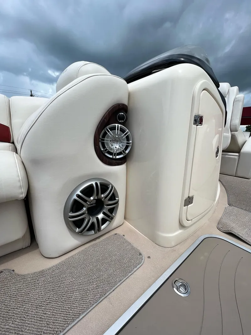 Slide: The Image of 2015 AquaPatio 240 SLR boat interior with speakers and storage compartment. - 4