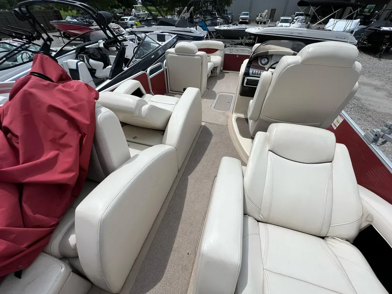 Slide: The Image of 2015 AquaPatio 240 SLR boat interior with white leather seats and red cover. - 6