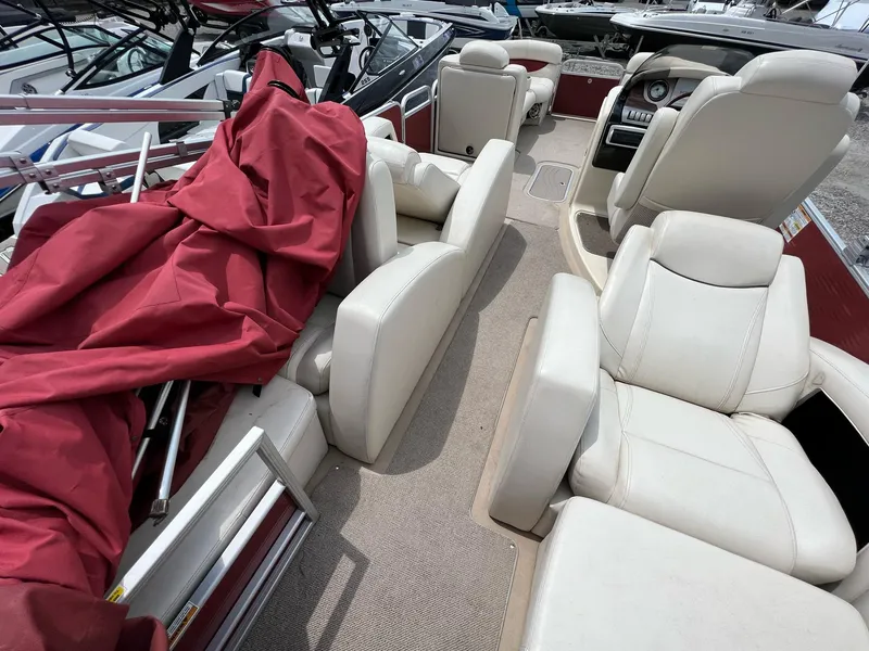 Slide: The Image of 2015 AquaPatio 240 SLR boat interior with white leather seats and red cover. - 7