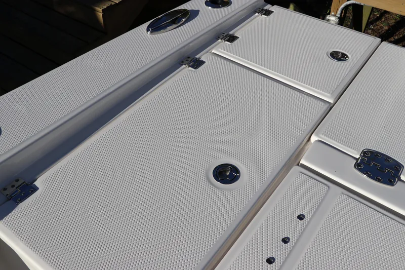 Slide: The Image of 2024 Robalo 266 Cayman boat deck with textured surface and storage compartments. - 11