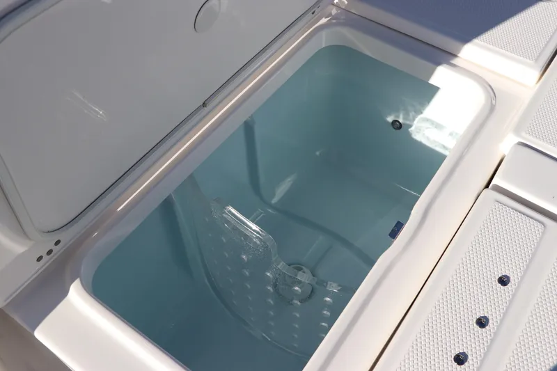 Slide: The Image of Livewell compartment on 2024 Robalo 266 Cayman boat, open and empty. - 12