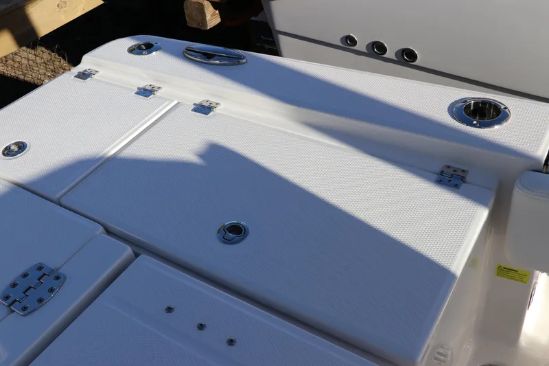Slide: The Image of 2024 Robalo 266 Cayman boat deck with storage compartments and fixtures. - 13