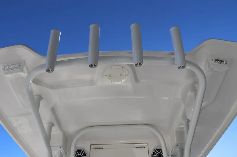 Slide: The Image of 2024 Robalo 266 Cayman boat roof with rod holders against blue sky. - 19