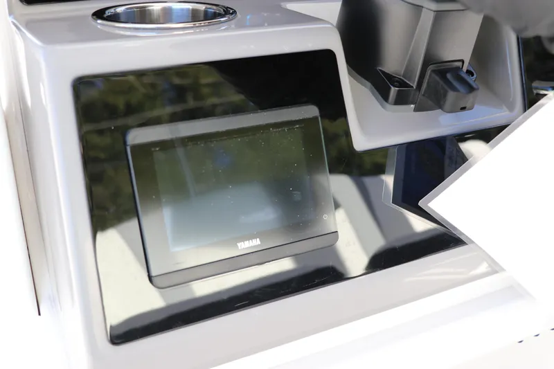 Slide: The Image of 2024 Robalo 266 Cayman dashboard with Yamaha display and cup holder. - 24