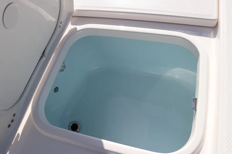 Slide: The Image of 2024 Robalo 266 Cayman livewell with open lid, showcasing interior. - 50