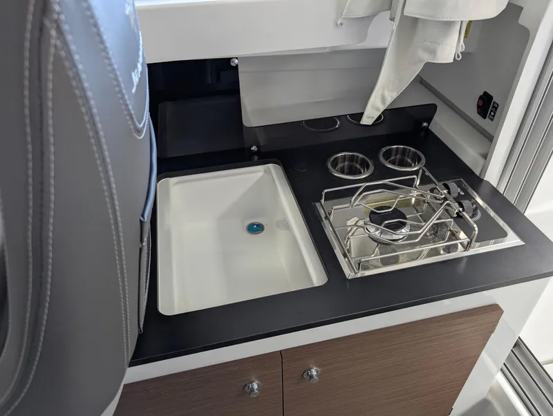 Slide: The Image of 2024 Jeanneau NC 695 Series 2 boat interior kitchen with sink and stove. - 11