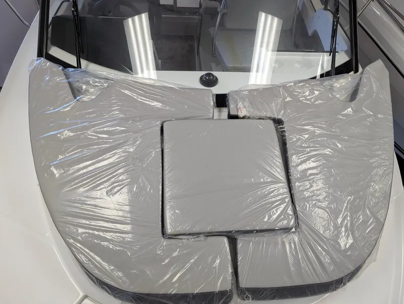 Slide: The Image of 2024 Jeanneau NC 695 Series 2 boat with protective covers on deck cushions. - 14