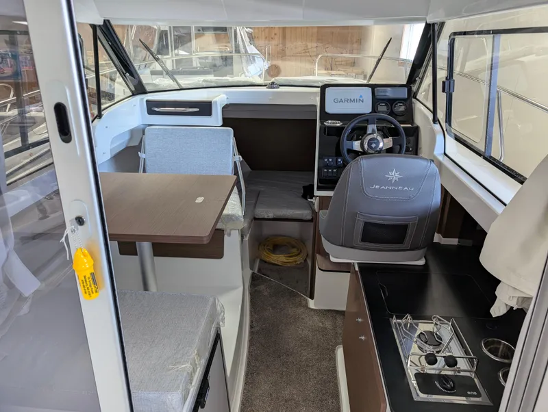 Slide: The Image of 2024 Jeanneau NC 695 Series 2 interior with helm, seating, and dining area. - 5