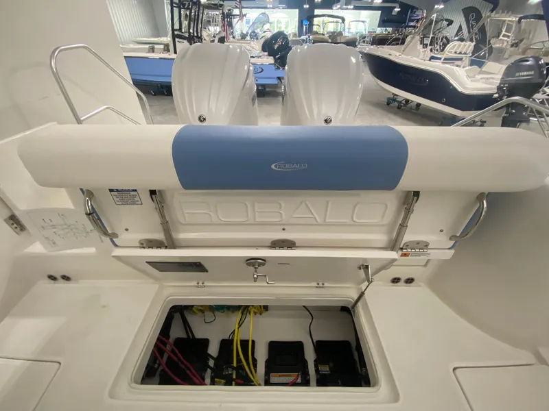 Slide: The Image of 2024 Robalo R302 boat interior with open storage compartment and twin engines. - 36