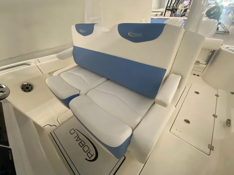Slide: The Image of 2024 Robalo R302 boat seating area with blue and white cushioned seats. - 46