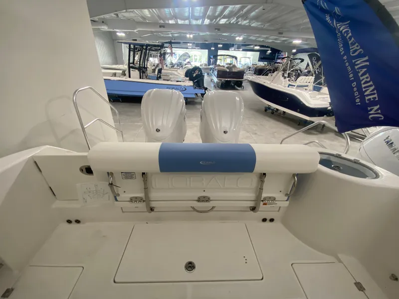 Slide: The Image of 2024 Robalo R302 boat interior with dual engines in a showroom. - 7