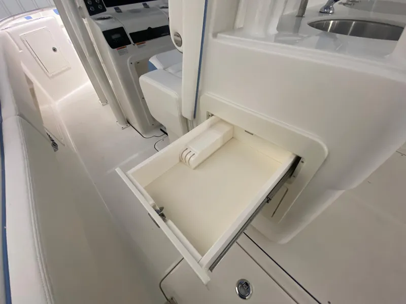 Slide: The Image of 2024 Robalo R302 boat interior with open storage drawer. - 22