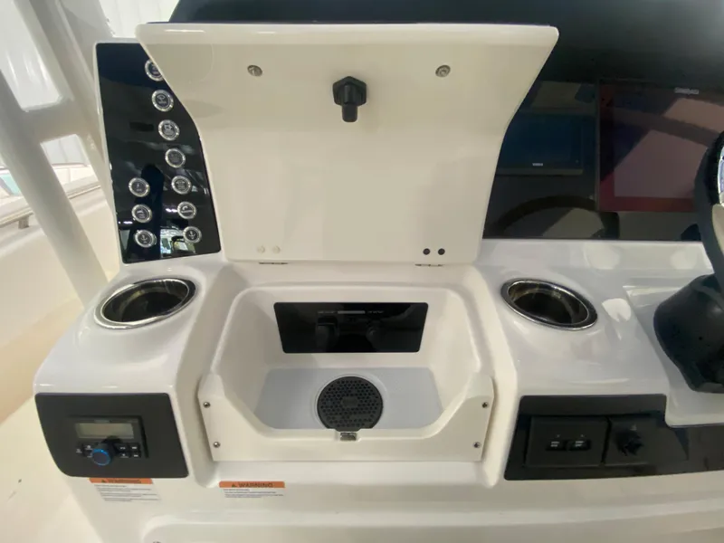 Slide: The Image of 2024 Robalo R302 boat console with storage compartment and cup holders. - 27