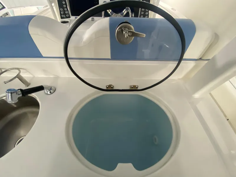Slide: The Image of 2024 Robalo R302 boat interior with sink and circular storage compartment. - 42