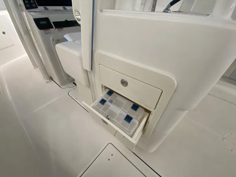 Slide: The Image of 2024 Robalo R302 boat storage compartment with tackle boxes. - 19
