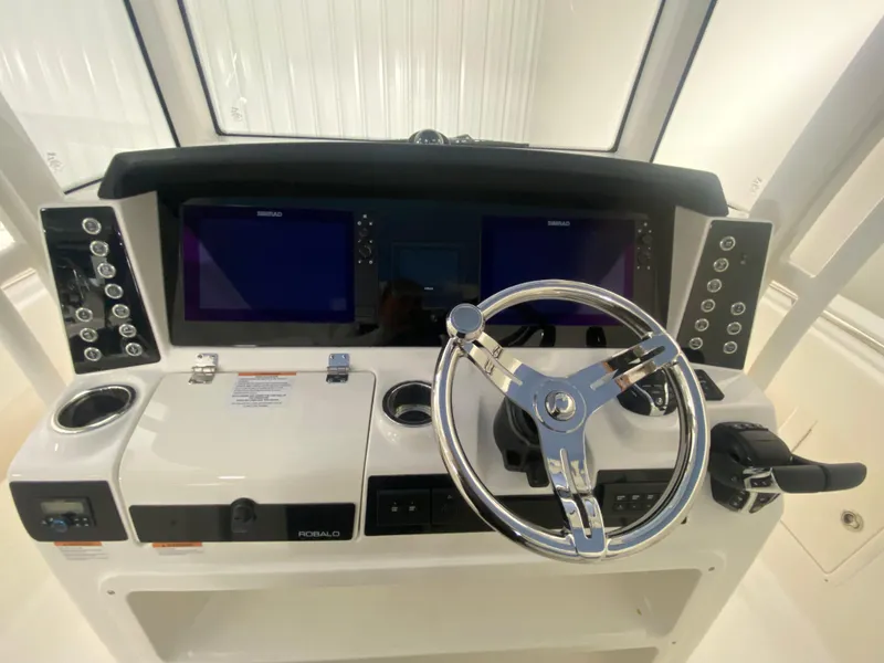 Slide: The Image of 2024 Robalo R302 boat dashboard with dual screens and steering wheel. - 23
