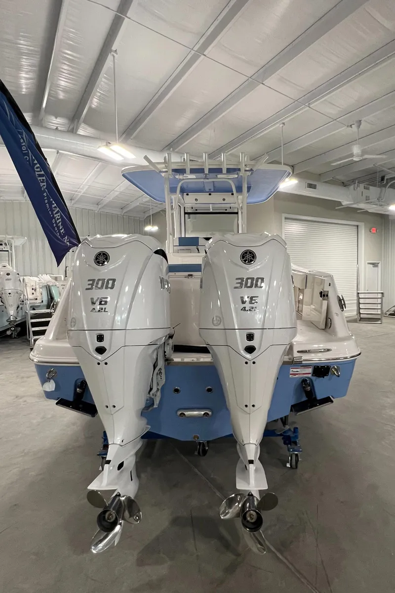 Slide: The Image of 2024 Robalo R302 boat with twin 300 V6 engines in a showroom. - 4