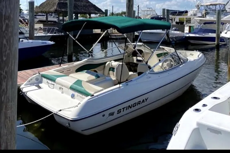 Slide: The Image of 2002 Stingray 180 LS/LX boat docked at a marina with green canopy. - 4