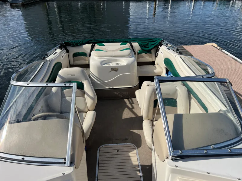 Slide: The Image of 2002 Stingray 180 LS/LX boat interior with seating, docked on calm water. - 5
