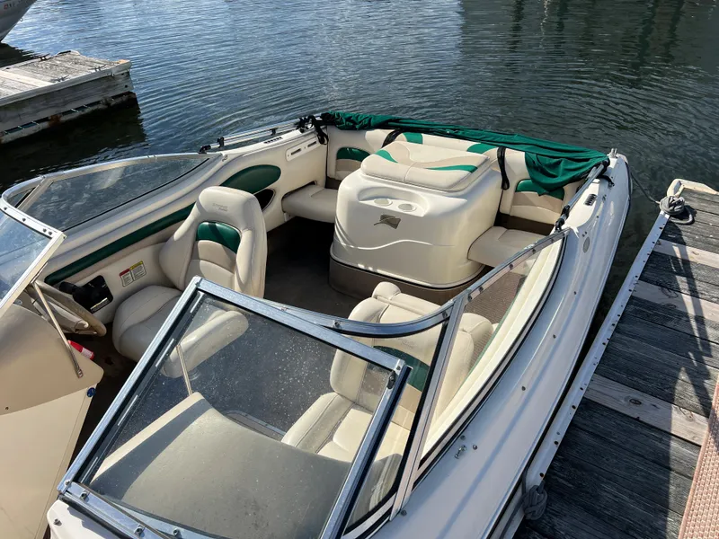 Slide: The Image of 2002 Stingray 180 LS/LX boat interior at dock, featuring white and green seating. - 9
