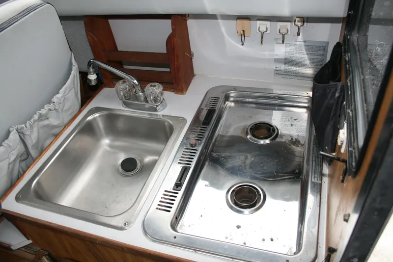 Slide: The Image of 1991 Olympic 23' Runabout boat kitchen with stainless steel sink and stove. - 11